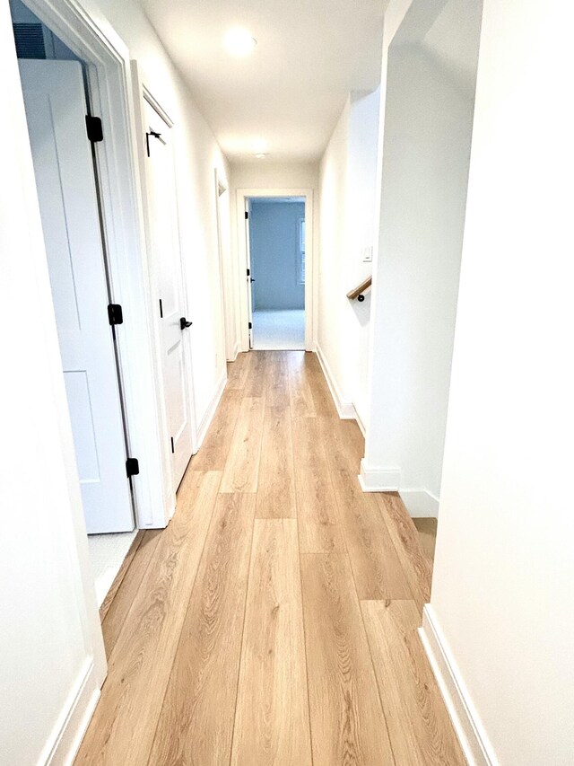 corridor with light hardwood / wood-style flooring