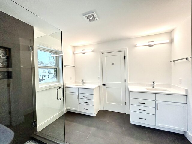 bathroom with a shower with door and vanity