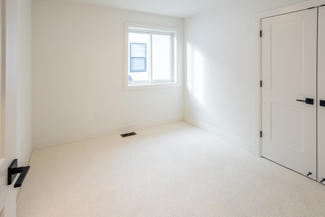 unfurnished room with light colored carpet