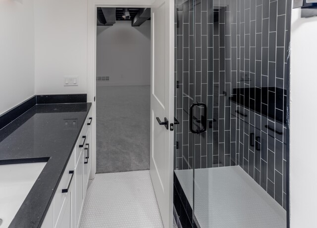 bathroom with tile patterned floors, vanity, and an enclosed shower