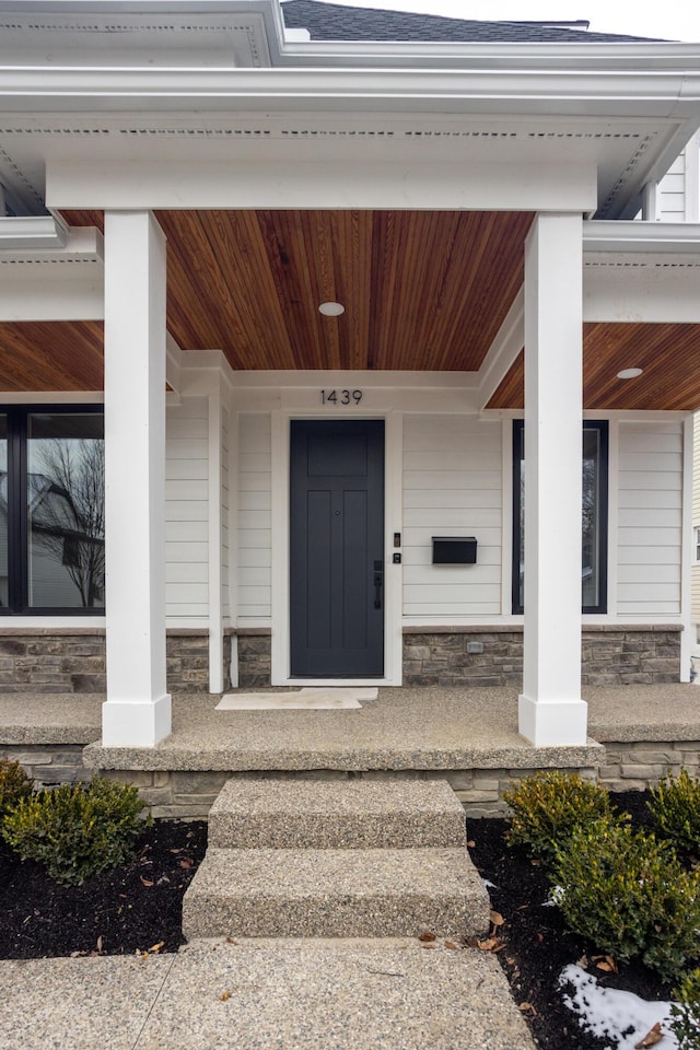 property entrance featuring covered porch and elevator