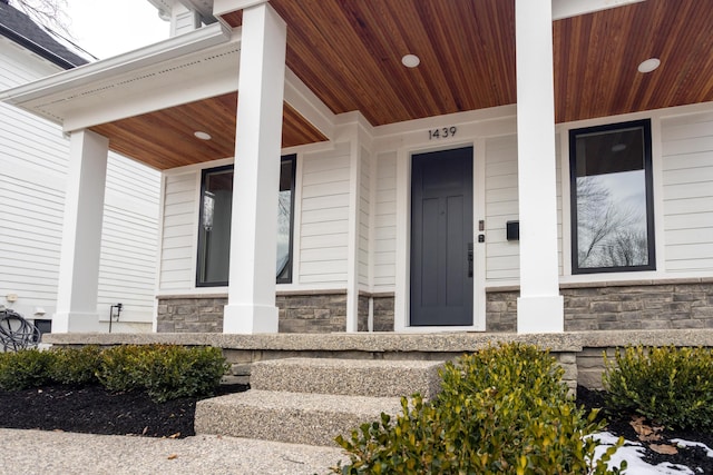 doorway to property featuring a porch and elevator