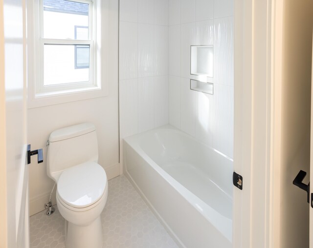 bathroom featuring tile patterned floors, bathing tub / shower combination, and toilet