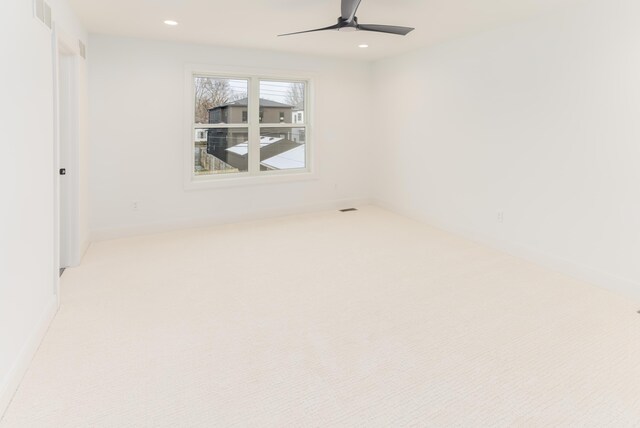 carpeted spare room featuring ceiling fan