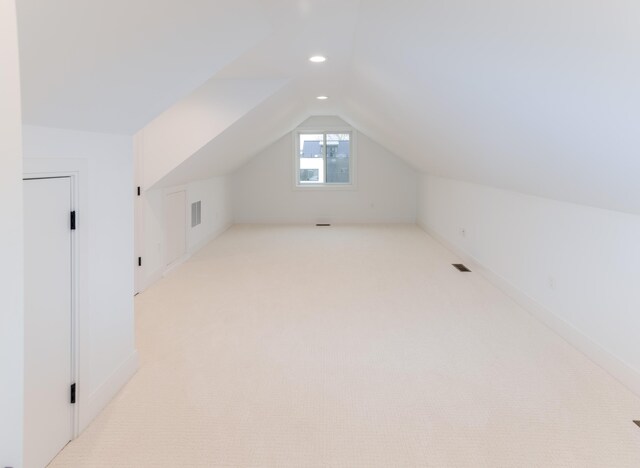 bonus room featuring light colored carpet and vaulted ceiling