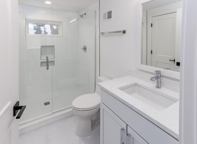 bathroom featuring walk in shower, tile patterned flooring, vanity, and toilet