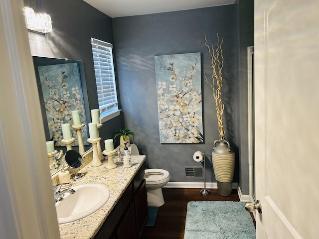 bathroom with hardwood / wood-style flooring, vanity, and toilet