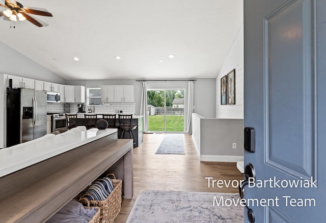 interior space with lofted ceiling, light hardwood / wood-style floors, and ceiling fan