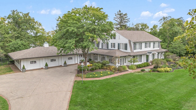 view of front of property featuring covered porch, a garage, and a front lawn