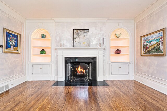 room details featuring ornamental molding, hardwood / wood-style floors, and built in shelves