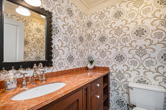 bathroom featuring toilet, ornamental molding, and vanity