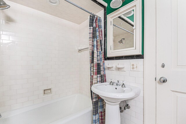 bathroom featuring tile walls and shower / tub combo