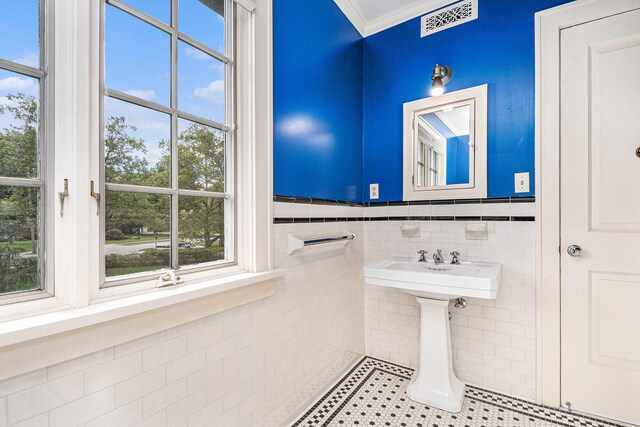 bathroom with tile walls and ornamental molding