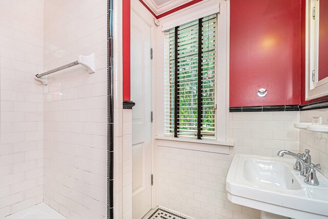 bathroom featuring sink, tile walls, and tiled shower