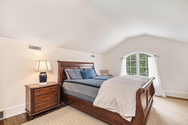 bedroom featuring lofted ceiling and dark hardwood / wood-style flooring