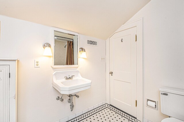 bathroom with toilet and vaulted ceiling