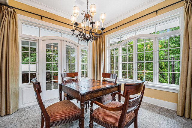 dining room with french doors, crown molding, an inviting chandelier, and plenty of natural light