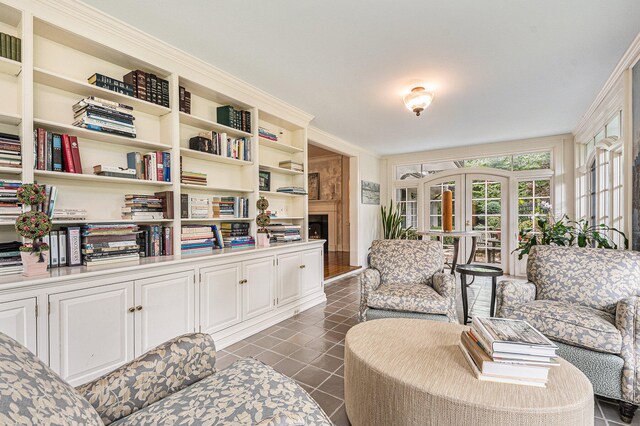 living area with ornamental molding and dark tile patterned floors