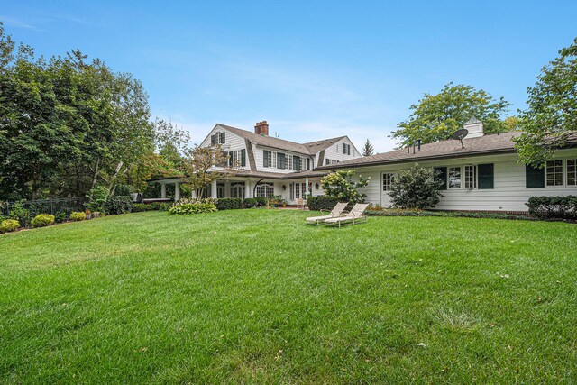 rear view of house featuring a lawn