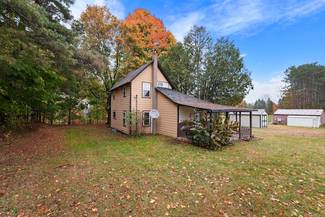 view of side of home with an outdoor structure and a yard