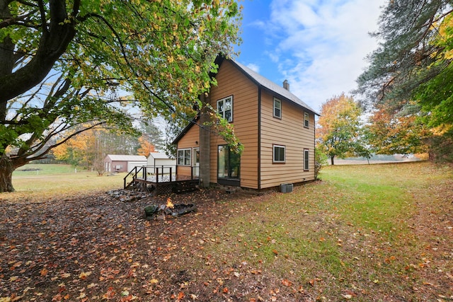 view of property exterior with a wooden deck and a lawn