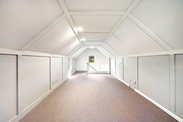 bonus room featuring baseboard heating, lofted ceiling, and light colored carpet