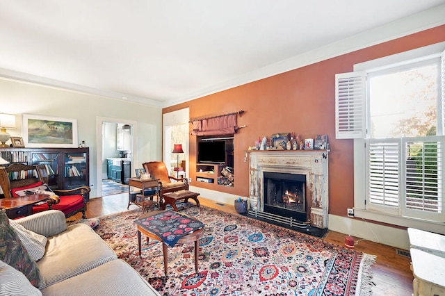 living room featuring ornamental molding and wood-type flooring