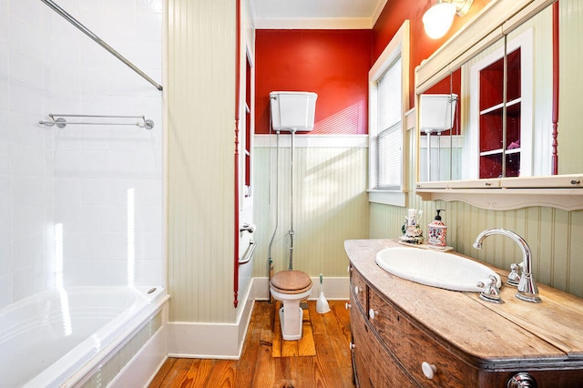 full bathroom with toilet, tiled shower / bath, hardwood / wood-style flooring, and vanity