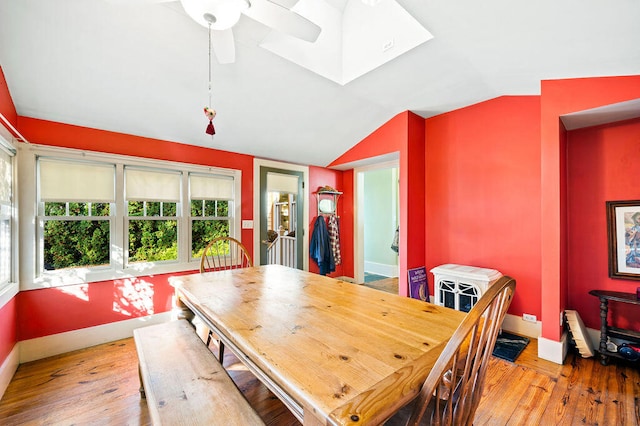 dining space with lofted ceiling with skylight, light hardwood / wood-style flooring, and ceiling fan