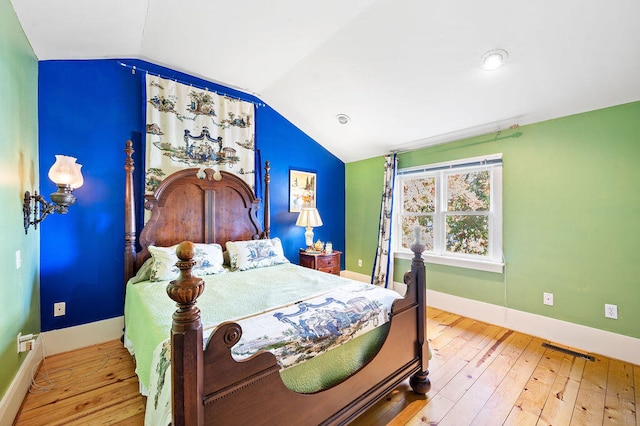 bedroom featuring hardwood / wood-style floors and vaulted ceiling