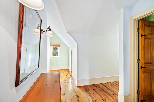 corridor with lofted ceiling and light wood-type flooring