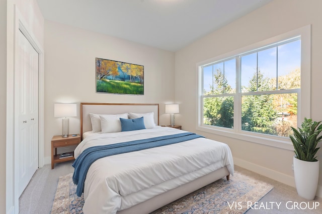 bedroom with light colored carpet and a closet