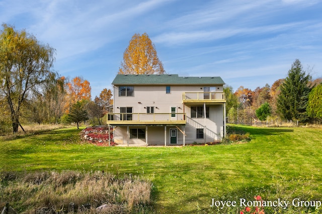 back of house featuring a wooden deck and a lawn