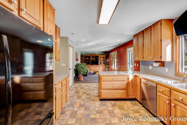 kitchen featuring sink, dishwasher, black refrigerator, and kitchen peninsula