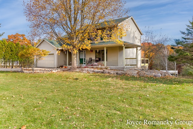 view of front of property with covered porch, a front lawn, and a garage