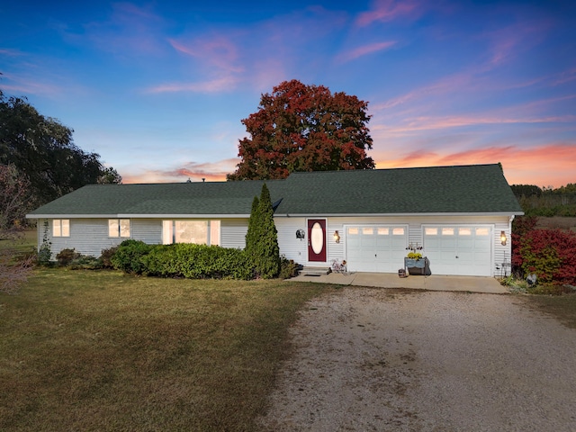 ranch-style home featuring a yard and a garage