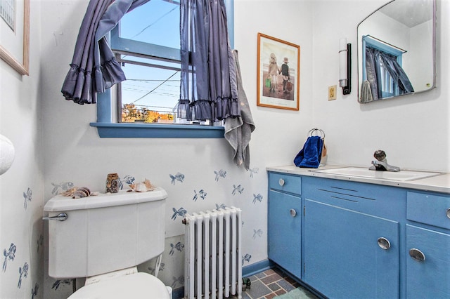 bathroom with vanity, toilet, and radiator