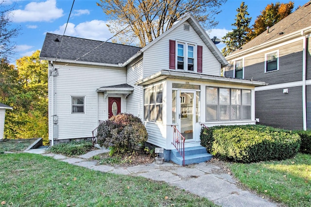 view of front facade featuring a front lawn and a sunroom