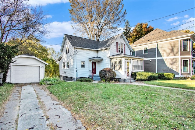 view of property with a garage, a front lawn, and an outbuilding