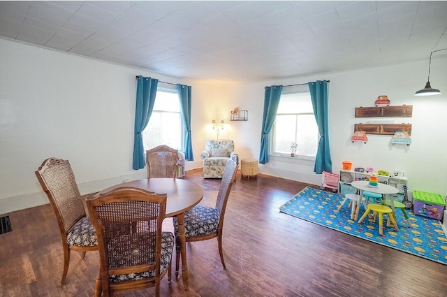 dining room with dark wood-type flooring and plenty of natural light