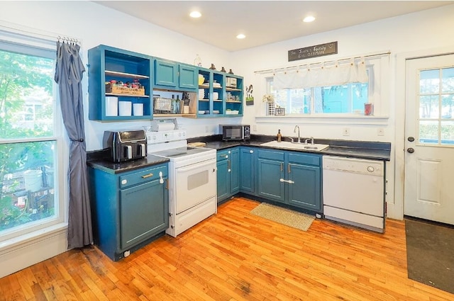 kitchen featuring white appliances, blue cabinetry, sink, and light wood-type flooring