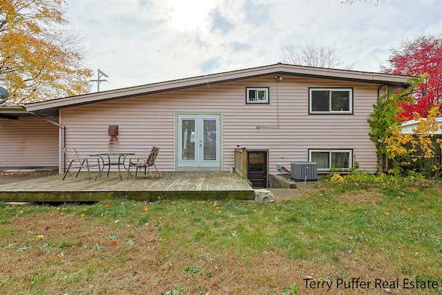 rear view of property with central air condition unit, french doors, a deck, and a lawn