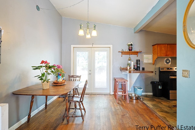 dining area with french doors, lofted ceiling with beams, hardwood / wood-style flooring, and a chandelier