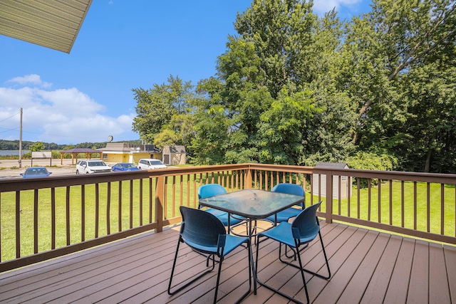 wooden deck with a shed and a lawn