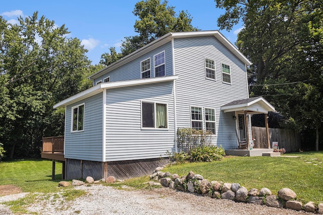 exterior space featuring a front yard and a wooden deck