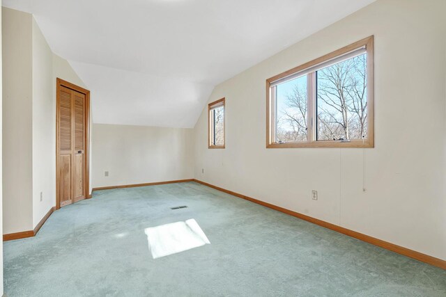 empty room featuring light colored carpet and vaulted ceiling