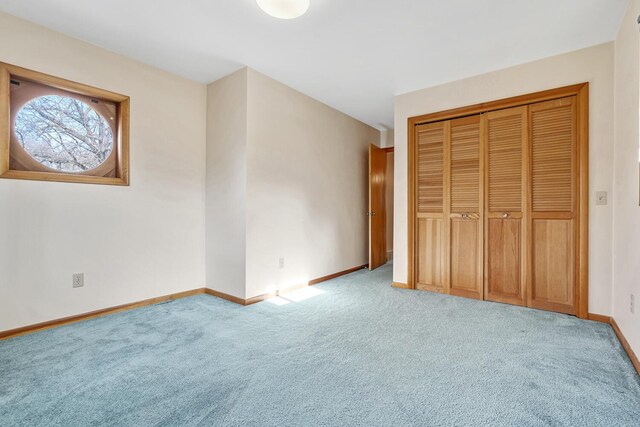 unfurnished bedroom featuring light colored carpet and a closet