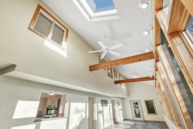 details with oven, beam ceiling, ceiling fan, and a skylight