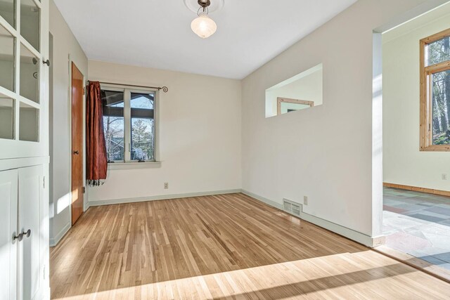 empty room with light hardwood / wood-style flooring and a healthy amount of sunlight