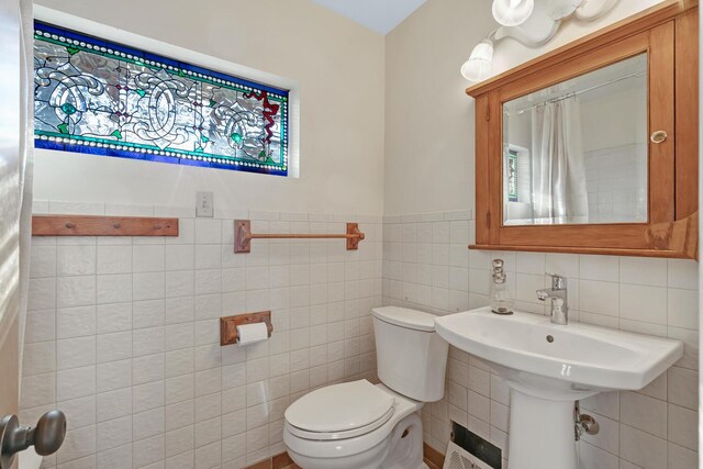 bathroom with tile walls and toilet